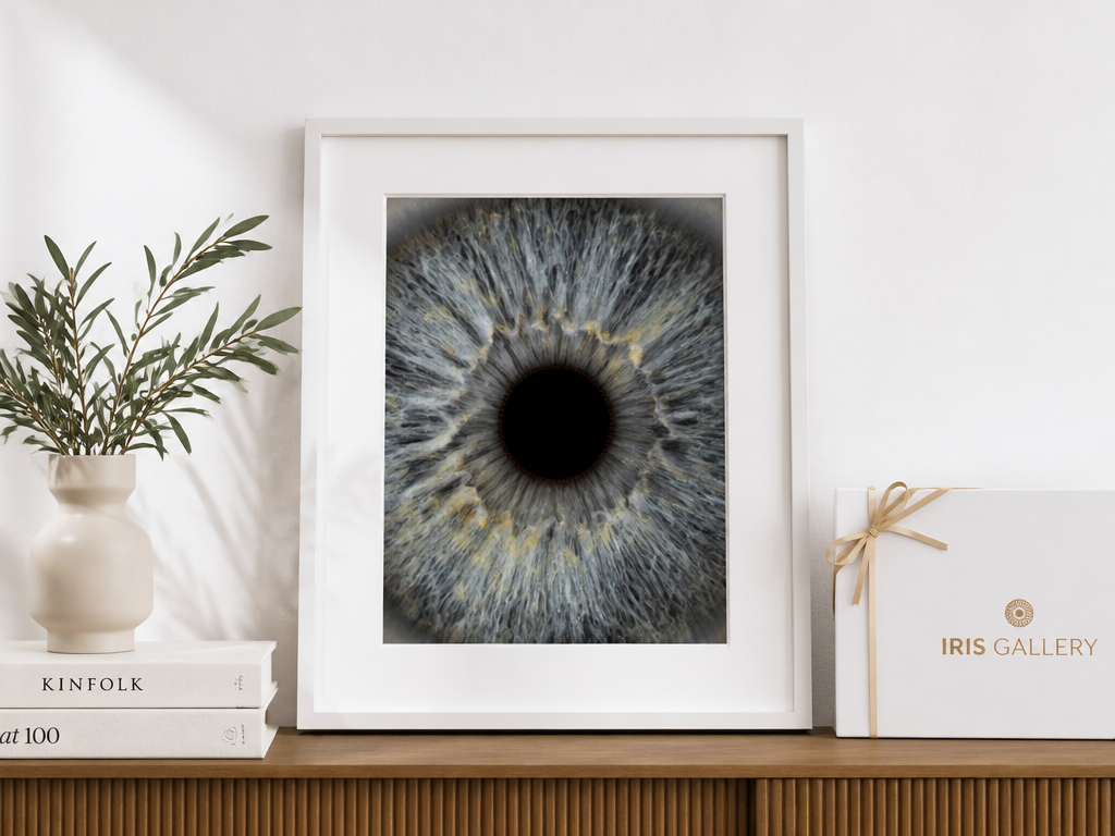 Cuadro blanco con fotografía de iris sobre mueble de madera